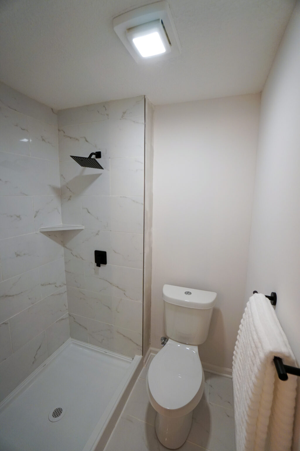 a bathroom with a white toilet and shower area